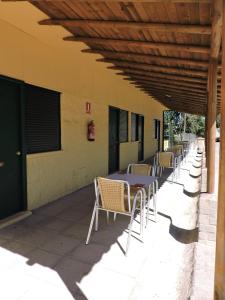 a row of tables and chairs on a patio at Hostal - Bungalows Camping Cáceres in Cáceres