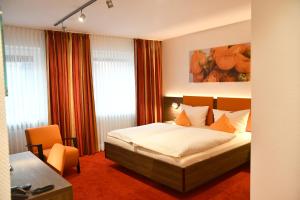 メッペンにあるホテル シュミット アム マルクトのベッドとデスクが備わるホテルルームです。