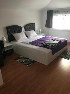 a bedroom with a bed with purple sheets and a window at Prenociste Bojan 017 in Vranje