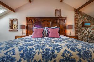 a bedroom with a blue and white bed with two lamps at Byfords in Holt