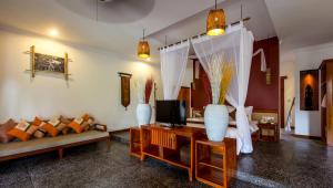 a living room with a couch and a tv at La Rivière d' Angkor Resort in Siem Reap