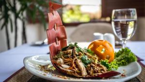 a plate of food on a table with a glass of wine at La Rivière d' Angkor Resort in Siem Reap