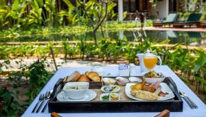 a tray of breakfast food on a table with a drink at La Rivière d' Angkor Resort in Siem Reap