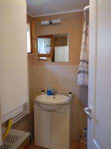 a bathroom with a white sink and a mirror at Gyöngy Vendégház in Szekszárd