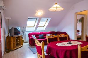 un soggiorno con divano rosso e tavolo di Kis-Gast Panoráma Apartman a Hajdúszoboszló