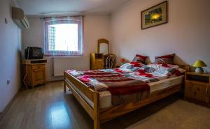 una camera con un grande letto e una televisione di Kis-Gast Panoráma Apartman a Hajdúszoboszló