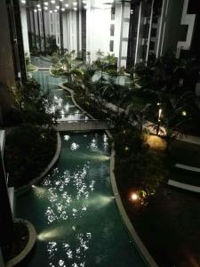 einen Innenpool in einem Gebäude mit Lichtern im Wasser in der Unterkunft M CITY Kl City in Kuala Lumpur