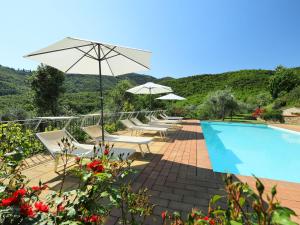 a pool with chairs and umbrellas next to at Villa Zen by Interhome in Santa Cristina