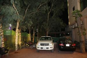 a white car parked next to a black car at Hotel Premier Inn Gulberg in Lahore