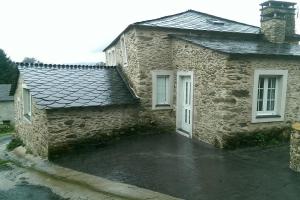 Casa de piedra con 2 ventanas y entrada en Casa Rural Ortigueira, en A Coruña