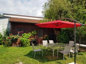 a table and chairs with a red umbrella in a yard at Apartman Maksimir Relax Zagreb-75m2 in Zagreb