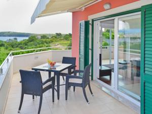 a patio with a table and chairs on a balcony at Apartment Jadranka-2 by Interhome in Rab