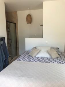 1 dormitorio con 1 cama con 2 almohadas en Guest House Olivades, en Cassis