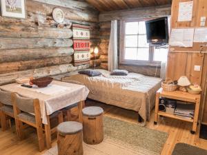 Blockhausschlafzimmer mit 2 Betten und einem Tisch in der Unterkunft Holiday Home Rukanpovi 6 by Interhome in Ruka