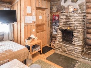 ein Schlafzimmer mit einem Kamin in einem Blockhaus in der Unterkunft Holiday Home Rukanpovi 6 by Interhome in Ruka