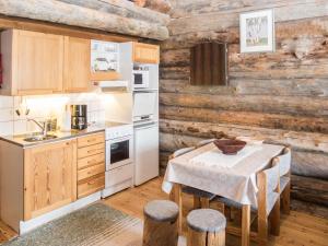 a kitchen with wooden walls and a table and chairs at Holiday Home Rukanpovi 6 by Interhome in Ruka