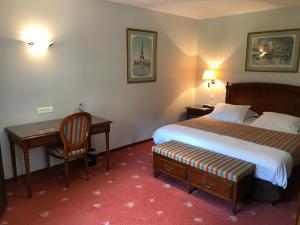 サンシー・レ・モーにあるシャトー ドゥ サンシーのベッドとデスクが備わるホテルルームです。