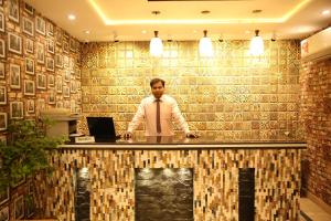 a man standing at a reception desk in a lobby at Premier Inn Gulberg Lahore in Lahore