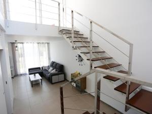 a spiral staircase in a living room with a couch at Holiday Home Xaloc by Interhome in L'Ampolla +14 photos