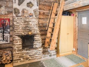 a fireplace in a log cabin with a ladder and a stove at Holiday Home Rukanpovi 6 by Interhome in Ruka