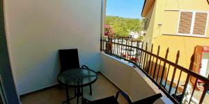 een balkon met een stoel, een tafel en een raam bij BEAUTIFUL HOUSE OF PSINTHOS in Psinthos