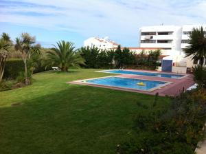 un gran patio con piscina y un edificio en Apartamento Navegantes, en Sintra