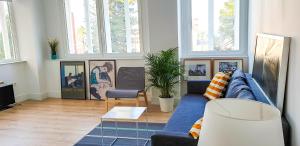 a living room with a blue couch and some windows at Luz de Cádiz in Cádiz