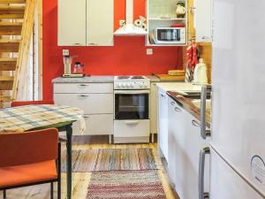 PunkalaidunにあるHoliday Home Muisku by Interhomeの赤い壁のキッチン(白いコンロ付)