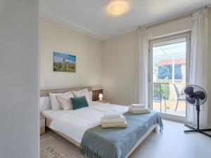 a white bedroom with a bed and a window at Holiday Home Villa Toni by Interhome in Umag
