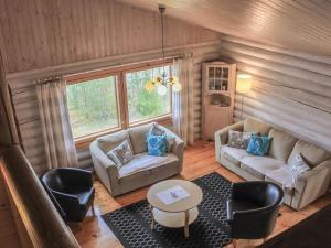ein Wohnzimmer mit einem Sofa, Stühlen und einem Tisch in der Unterkunft Holiday Home Kalliokoivu by Interhome in Torvoila