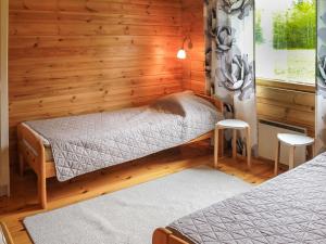 een slaapkamer met een bed in een houten muur bij Holiday Home Pihlaja by Interhome in Torvoila