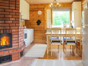 een keuken met een open haard en een tafel en stoelen bij Holiday Home Pihlaja by Interhome in Torvoila
