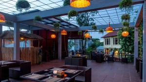 een restaurant met oranje verlichting en tafels en mensen op de achtergrond bij La Rivière d' Angkor Resort in Siem Reap