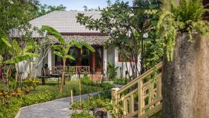 a house with a garden and a wooden fence at La Rivière d' Angkor Resort in Siem Reap