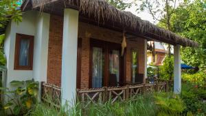 a small house with a straw roof at La Rivière d' Angkor Resort in Siem Reap