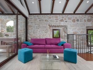 een woonkamer met een paarse bank en blauwe krukken bij Holiday Home Villa Matija by Interhome in Drivenik +30 foto's