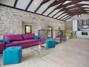 een woonkamer met een paarse bank en een tafel bij Holiday Home Villa Matija by Interhome in Drivenik