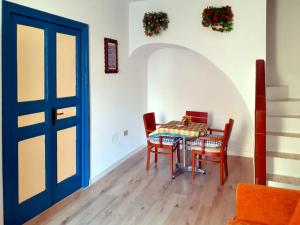 a dining room with a table and chairs and a blue door at Flamingo Room in Castellammare del Golfo