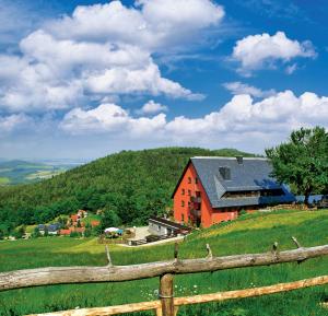 une grange au sommet d'une colline avec une clôture dans l'établissement Hubertusbaude, à Waltersdorf