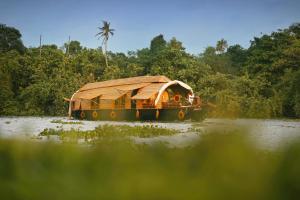 阿勒皮Spice Coast Cruises - Houseboat, A CGH Earth Experience的一条河上带竹屋顶的船