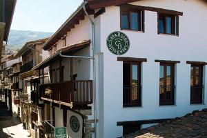 a building with a sign on the side of it at Aptos La Ceja, El Trampal y El Reloj by CASA BOLDO in Candelario