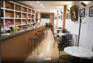 a restaurant with a bar with chairs and tables at Hostal Calderon Cuenca in Cuenca