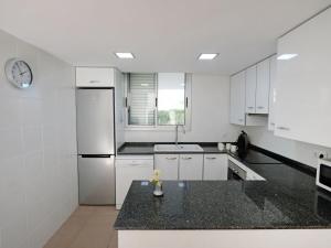 a kitchen with white cabinets and a black counter top at Holiday Home Estrella by Interhome in L'Ampolla