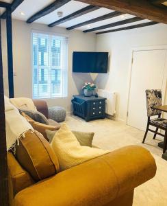 a living room with a yellow couch and a tv at Bridgnorth B&B in Bridgnorth