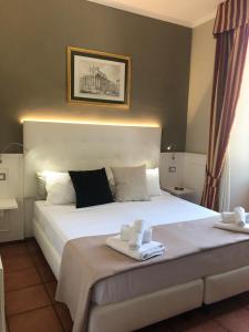 a bedroom with a large white bed with towels on it at 207 Inn in Rome