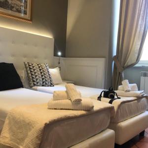 2 Betten in einem Hotelzimmer mit Handtüchern darauf in der Unterkunft 207 Inn in Rom