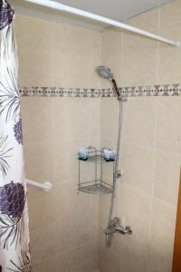 een douche met een douchegordijn in de badkamer bij North Shore Apartment in Eilat