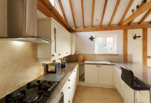 a kitchen with white cabinets and a stove top oven at Owl's Hoot in Thorndon