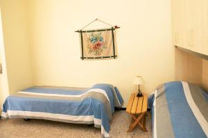 1 dormitorio con 2 camas y mesa con lámpara en Casa Abba, en Alessandria