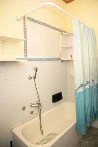 y baño con bañera y cortina de ducha. en Casa Abba, en Alessandria